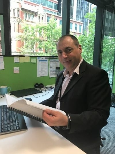 An Ombudsman staff member is sitting at his desk, reading through a document.